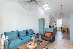 sala de estar con sofá azul y mesa en Sieck - Joli Appartement Vue mer en Carantec