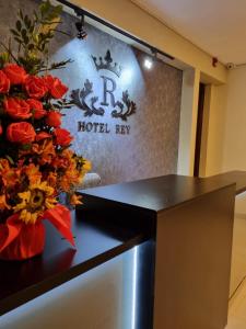 una camera d'albergo con un cartello e fiori su un tavolo di Hotel Rey a Huancayo