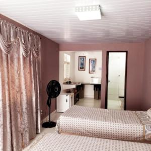 a bedroom with two beds and a bathroom at Natal Aconchegante in Natal