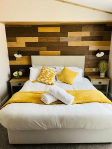 a bedroom with a bed with two towels on it at Barakah Lodge with Hot Tub in York