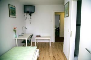 a bedroom with a bed and a desk and a tv at Hotel Hoffmann in Essen