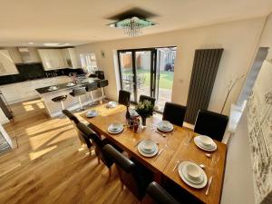 una sala da pranzo e una cucina con tavolo e sedie di Luxury Pamper Home Hot Tub & Sauna Ladies Retreat a Ferndown