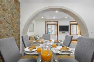 a dining room with a table with food and orange juice at WHome | Alfama Deluxe Apartment in Lisbon