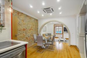 a kitchen and dining room with a stone wall at WHome | Alfama Deluxe Apartment in Lisbon