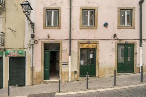 a building with green doors on a street at WHome | Alfama Deluxe Apartment in Lisbon