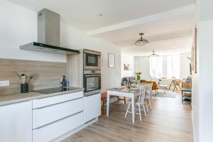 une cuisine avec des placards blancs et une salle à manger dans l'établissement Callot, à Carantec