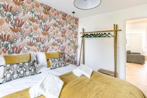 - une chambre avec un grand lit et du papier peint floral dans l'établissement Callot, à Carantec