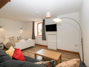 a living room with a bed and a couch at Lower Venn Granary Apartment 1 in Wellington