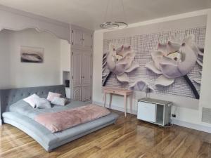 1 dormitorio con 1 cama y flores en la pared en LES GENEBRUYERES - L'HISTOIRE D'UN REVE, en Aubigny-sur-Nère