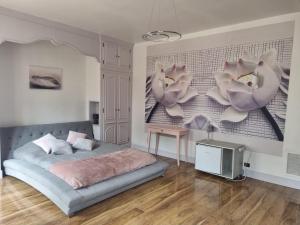 a bedroom with a bed and flowers on the wall at LES GENEBRUYERES - L'HISTOIRE D'UN REVE in Aubigny-sur-Nère