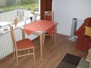 a small table and chairs in a room with a window at Apartment im Haus Hanseatic mit Meerblick am Duhner Sandstrand in Cuxhaven