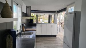 a kitchen with white cabinets and a sink and a refrigerator at VILLA GAELCA in Arona