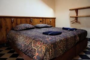 a bed in a room with two blue pillows on it at Hostel Kersenhof in Uden