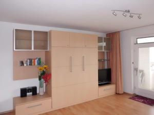 sala de estar con armario grande y TV en Apartment im Haus Hanseatic mit Meerblick am Duhner Sandstrand, en Cuxhaven