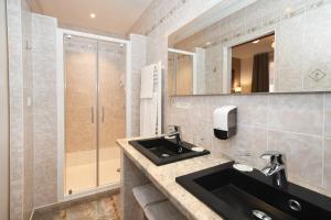 a bathroom with a sink and a shower at Logis Hôtel du Centre - Halte idéale en cyclotourisme avec garage à vélos clos in Molsheim