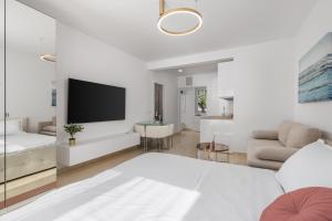 a white living room with a television and a couch at Luxury Studio Apartment Honeymoon in Selce