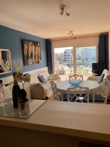 Apt Port Rhodes C, 2 chbres, 2 terrasses, vue sur canal principal de la marina et sur les pyrénées في إمبوريابرافا: غرفة معيشة مع طاولة وأريكة