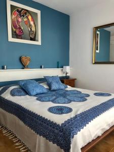 ein Schlafzimmer mit einem großen Bett mit blauen Wänden in der Unterkunft Apt Port Rhodes C, 2 chbres, 2 terrasses, vue sur canal principal de la marina et sur les pyrénées in Empuriabrava
