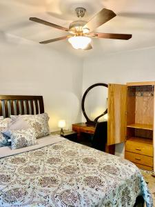 a bedroom with a bed with a ceiling fan at Cozy well- appointed apartment on Mas & Ri line in Pawtucket