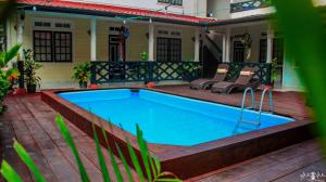 a swimming pool on a patio next to a house at Zeelandia Suites in Paramaribo