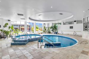 - une grande piscine dans un bâtiment avec piscine dans l'établissement Hotel Mortagne, à Boucherville