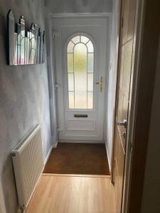 um corredor com uma porta branca e uma janela em Holiday Home in Cardiff which sleep 5 and we try and make it a home from home em Cardiff