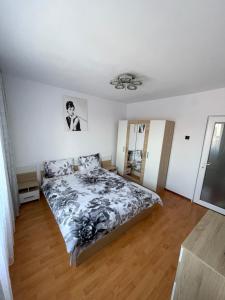 a bedroom with a bed with a black and white comforter at Apartament Oskar in Jurilovca