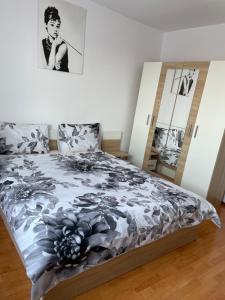 una camera da letto con un letto con un piumone bianco e nero di Apartament Oskar a Jurilovca