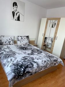 a bedroom with a bed with a black and white comforter at Apartament Oskar in Jurilovca