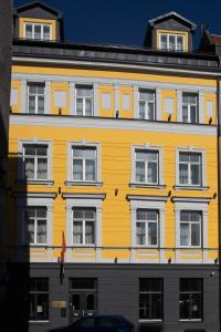 a yellow building with windows on the side of it at Old Riga Plaza Hotel in Rīga