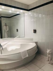 a white bath tub in a bathroom with a mirror at Hotel Restaurant Chavant in Bresson