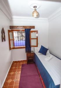 a small bedroom with a bed and a window at Hotel Al kassaba in Chefchaouen