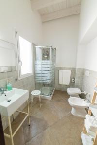 ein Badezimmer mit zwei Waschbecken, einem WC und einer Dusche in der Unterkunft Civico 47 in Càbras