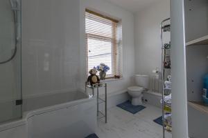 a bathroom with a tub and a toilet at millennium stadium guest house in Cardiff