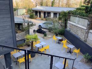 una vista aérea de un patio con sillas y mesas amarillas en Hôtel Monet, en Honfleur