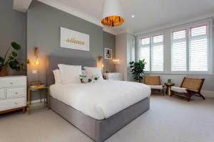1 dormitorio con 1 cama blanca grande y ventanas en Veeve - Electric Dreams, en Londres