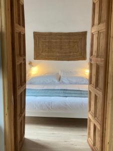 ein Schlafzimmer mit einem Bett und einer offenen Tür in der Unterkunft CAN LLAVI - LLAUT in Canet de Mar
