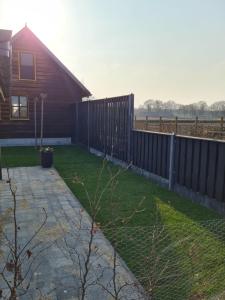 a yard with a fence and a house at 't Hûske in Venhorst +35 photos