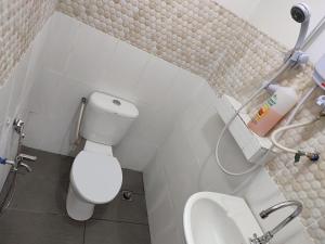 a bathroom with a white toilet and a sink at Sinurambi 2 in Kampong Kundassan +56 photos