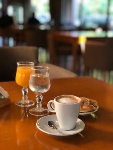 Mestizo Hotel في لينكولن: كوب من القهوة على طاولة مع كوب من عصير البرتقال