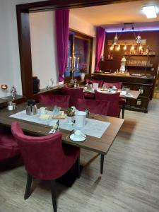 a restaurant with tables and chairs and purple curtains at Hotel Engelbracht inklusive MeineCardPlus in Willingen