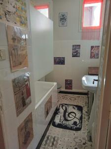 uma casa de banho com WC e um lavatório com fotografias na parede em Appartement le labyrinthe du peintre em Bransat