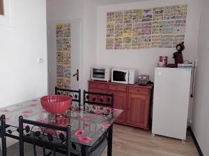 a kitchen with a table and a white refrigerator at Appartement le labyrinthe du peintre in Bransat +12 photos