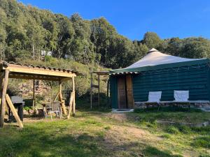 ein blaues Gebäude mit zwei Stühlen und einem Pavillon in der Unterkunft Cabane 2 in Olivese