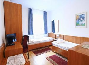 um quarto de hotel com duas camas e uma televisão em Hotel Wesselényi em Gyor