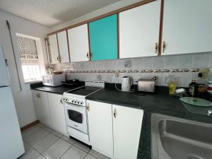 a kitchen with white cabinets and a sink at SEAmply Villa by A.C.I. in Jolly Harbour