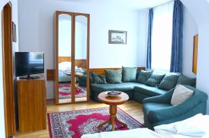 a living room with a couch and a tv at Hotel Wesselényi in Győr