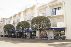 a building with tables and chairs in front of it at Le Calypso in Dax