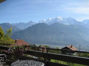 d'un balcon avec une table et une vue sur les montagnes. dans l'établissement Mont Blanc Views Apartments, à Passy