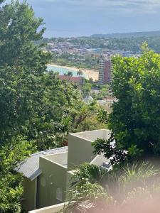 - une vue sur une maison au milieu des arbres dans l'établissement Coastal Beauty - Beautiful Penthouse Condo in Ocho Rios, à Ocho Rios